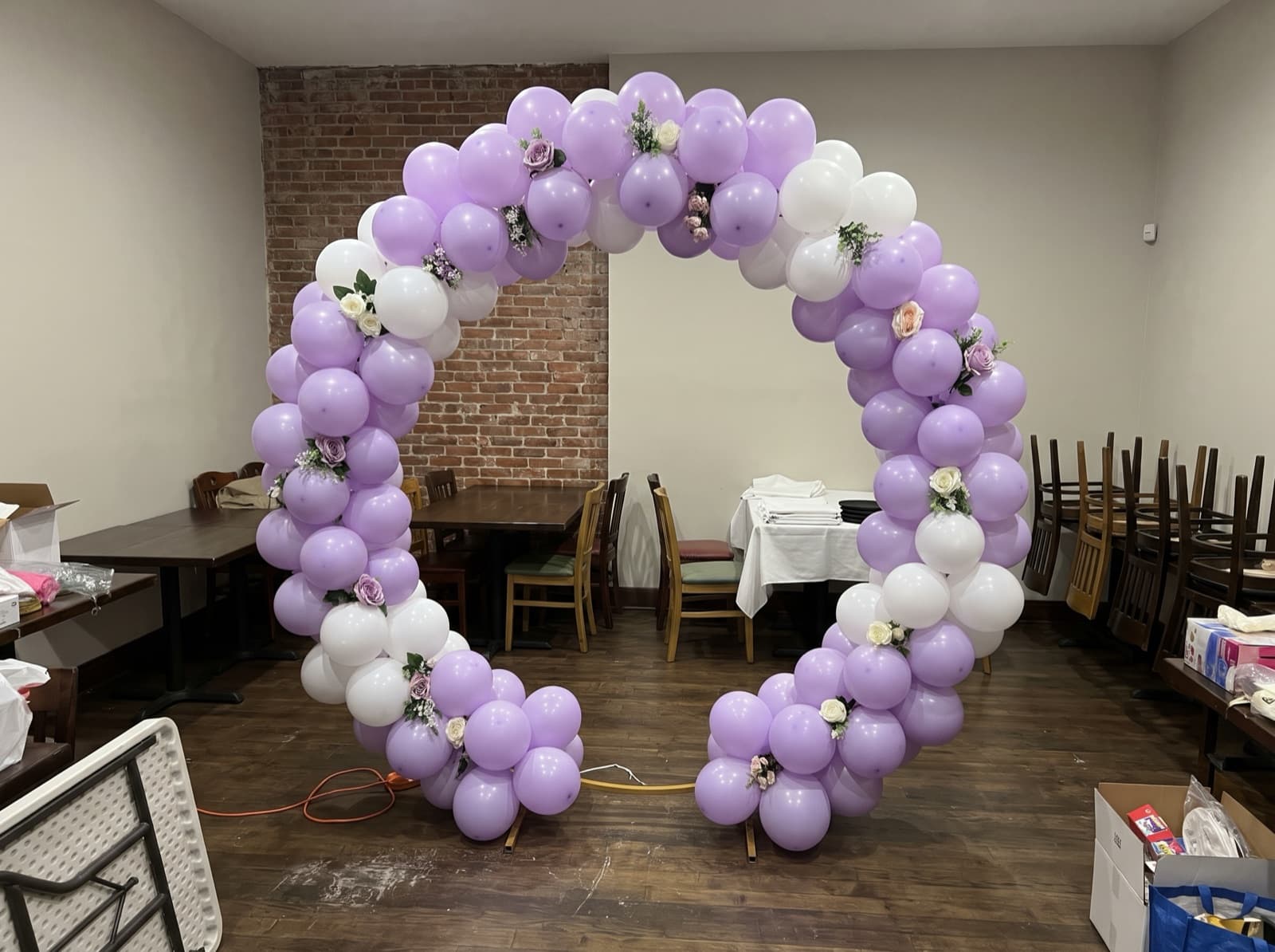 Round balloon arch with lilac and white balloons framing a photo spot