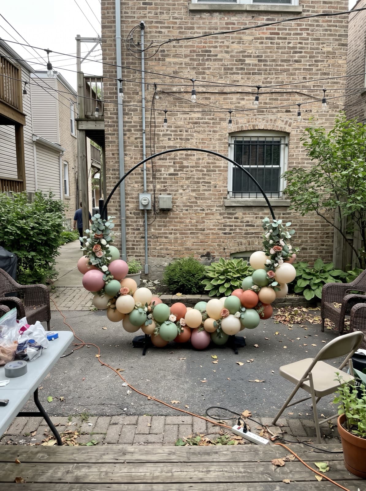 Balloon hoop backdrop with florals in a city backyard