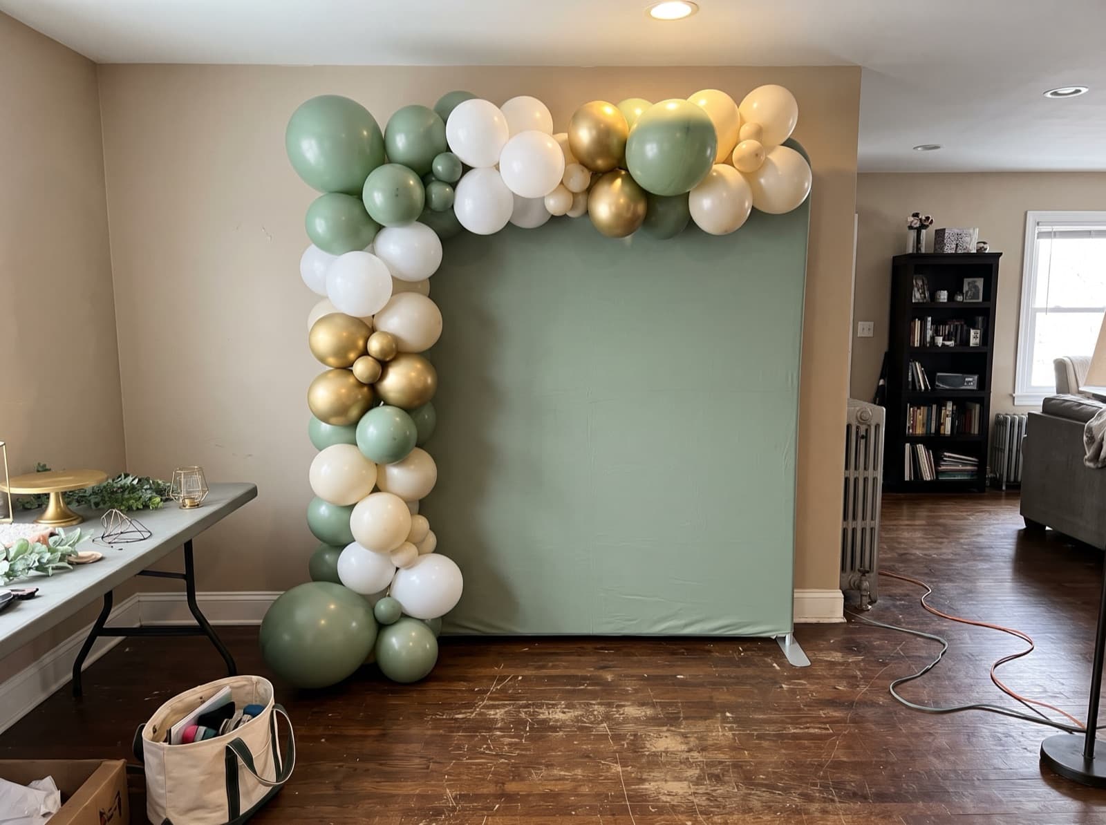 Square sage green backdrop panel trimmed with a balloon garland