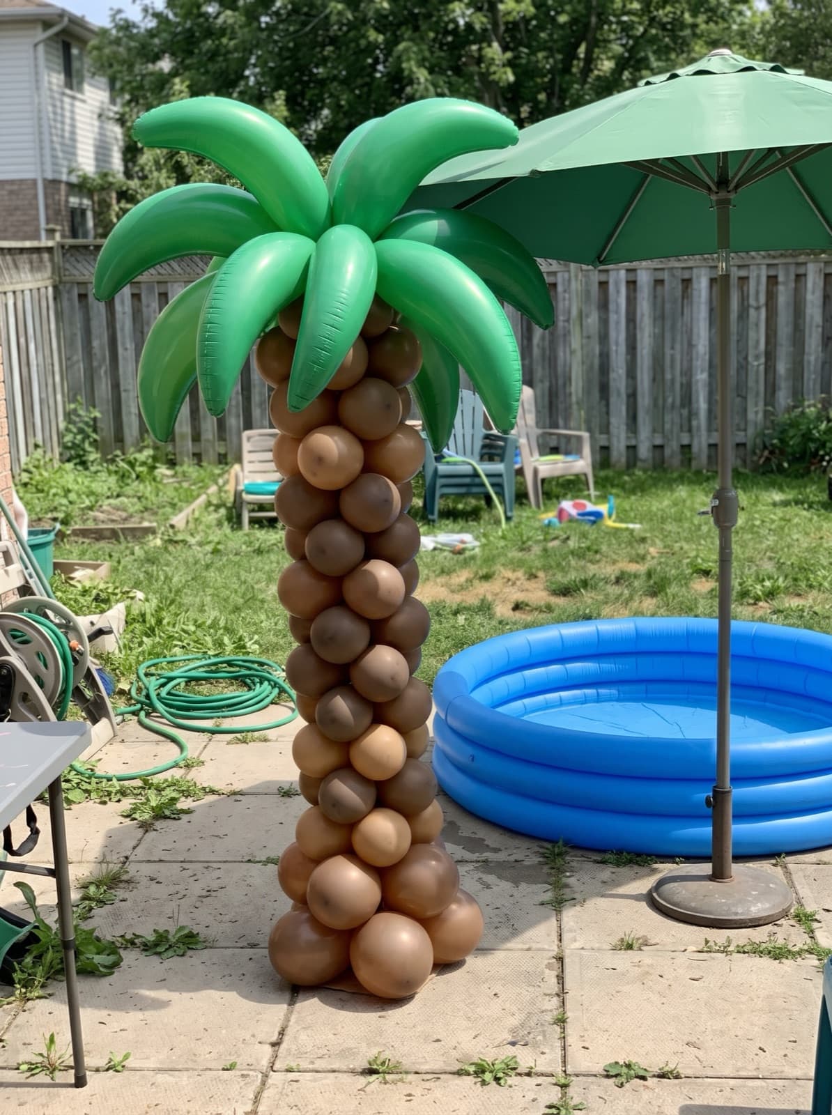 Palm tree balloon column beside a backyard patio