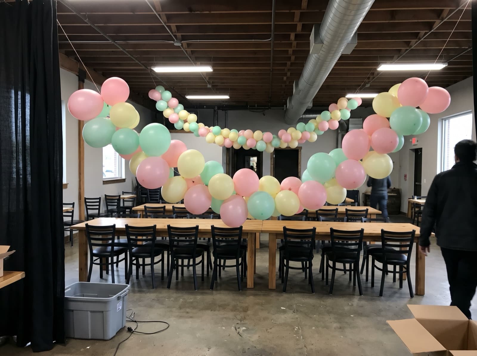 Hanging balloon garland canopy over long dining tables