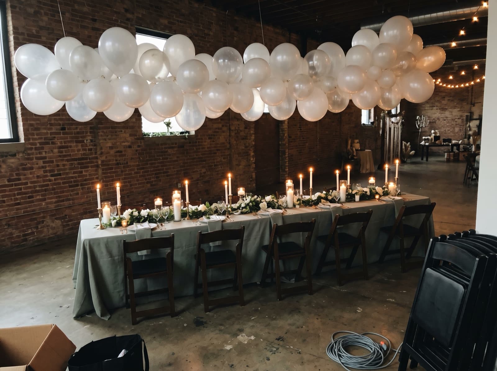 Balloon cloud over a sweetheart table in a loft reception