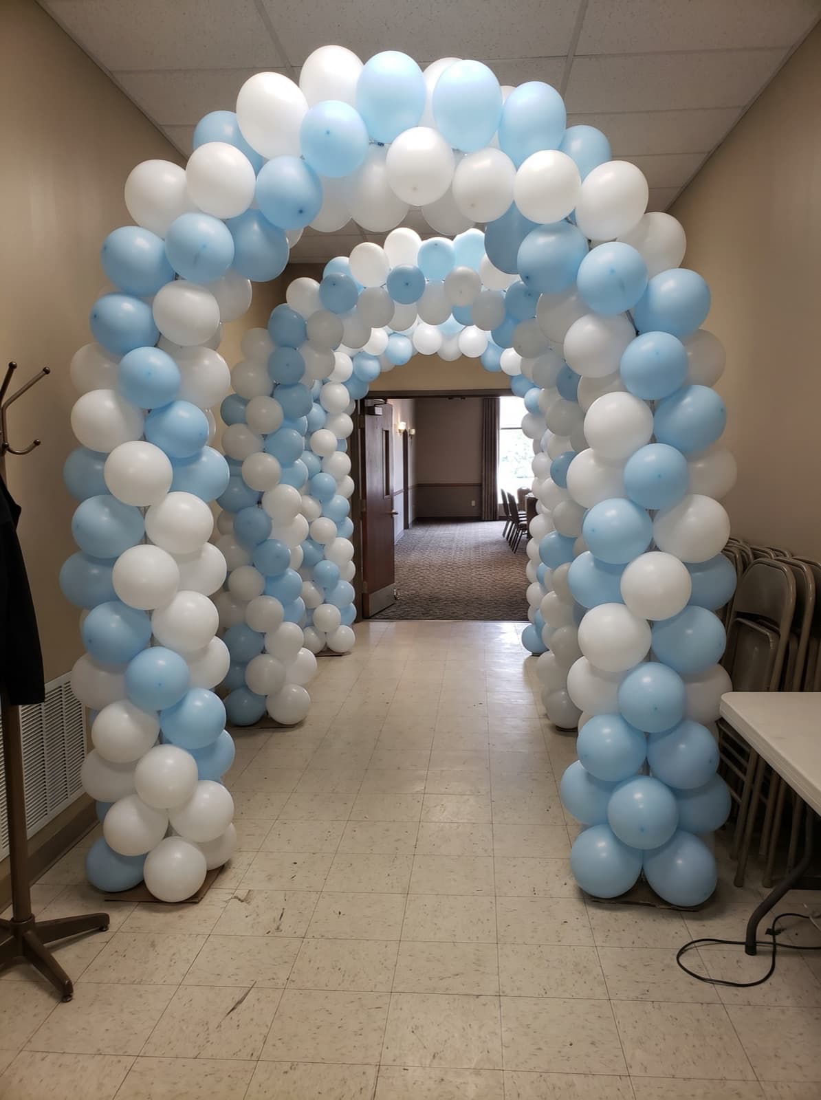 Balloon tunnel entrance of linked arches in white and powder blue